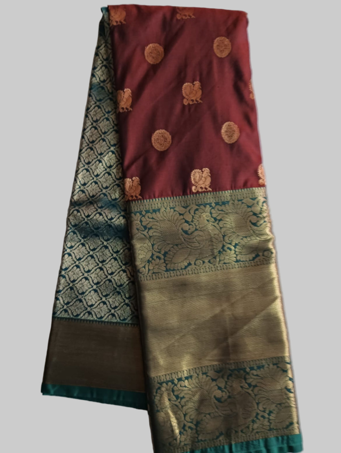 Traditional saree with maroon and green patterns on a white background
