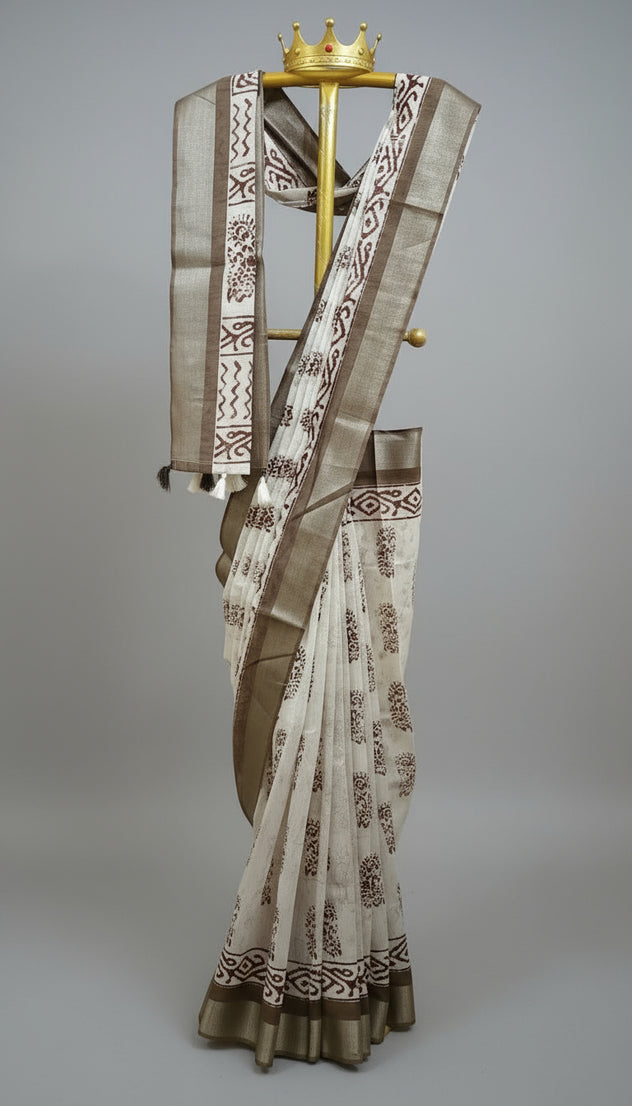 Saree with intricate patterns on a stand against a white and black curtain background