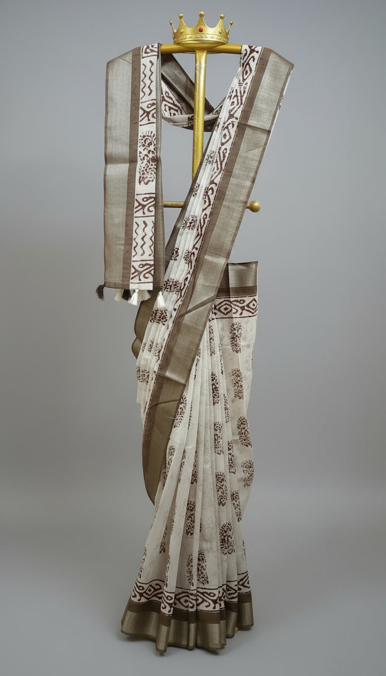 Saree with intricate patterns on a stand against a white and black curtain background
